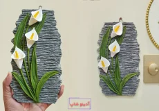 تابلو تزیینی برجسته با طرح گل شیپوری سفید و برگ‌های سبز ساخته شده از گچ روی دیوار