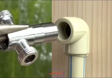 اتصال سه‌راهی فلزی به زانویی پلاستیکی لوله سفید با استفاده از انبردست در تعمیرات لوله‌کشی