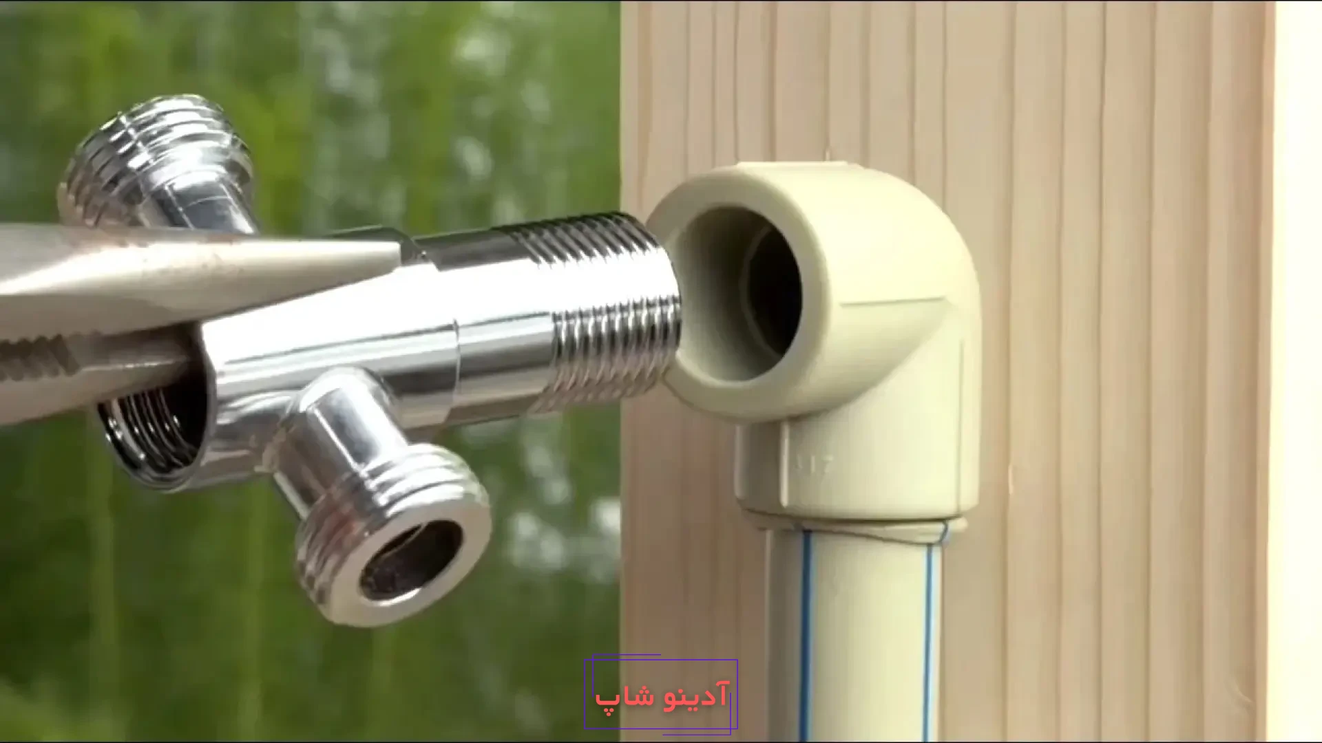 اتصال سه‌راهی فلزی به زانویی پلاستیکی لوله سفید با استفاده از انبردست در تعمیرات لوله‌کشی