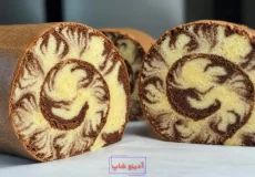 کیک رولت دو رنگ وانیلی و شکلاتی با طرح طوفانی و بافت اسفنجی نرم