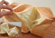 نمای نزدیک از بافت پنبه‌ای و رشته‌رشته نان شیرمال ژاپنی هنگام تکه کردن با دست